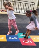 Enfants jouant sur une marelle 8 cases DecoMark appliquée dans une cour d'école 2