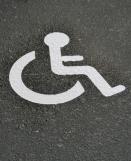 Sigle handicapé T SIGN blanc pré-billé appliqué sur une place de parking